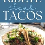 Two tacos next to each other on a plate with cillantro, lime, cojita cheese.