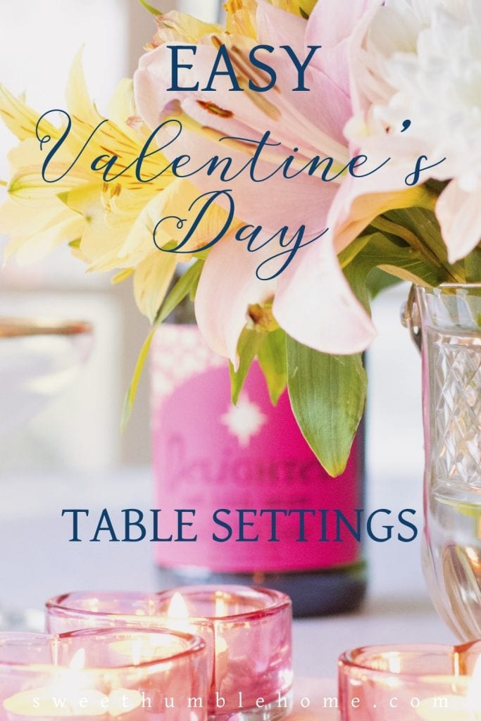 A simple flower arrangment on a table with champagne in a pink bottle. 